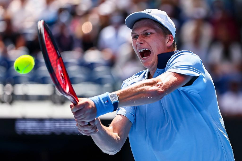 Il tennista statunitense Jenson Brooksby con completo celeste colpisce la palla di rovescio durante un torneo nel circuito ATP